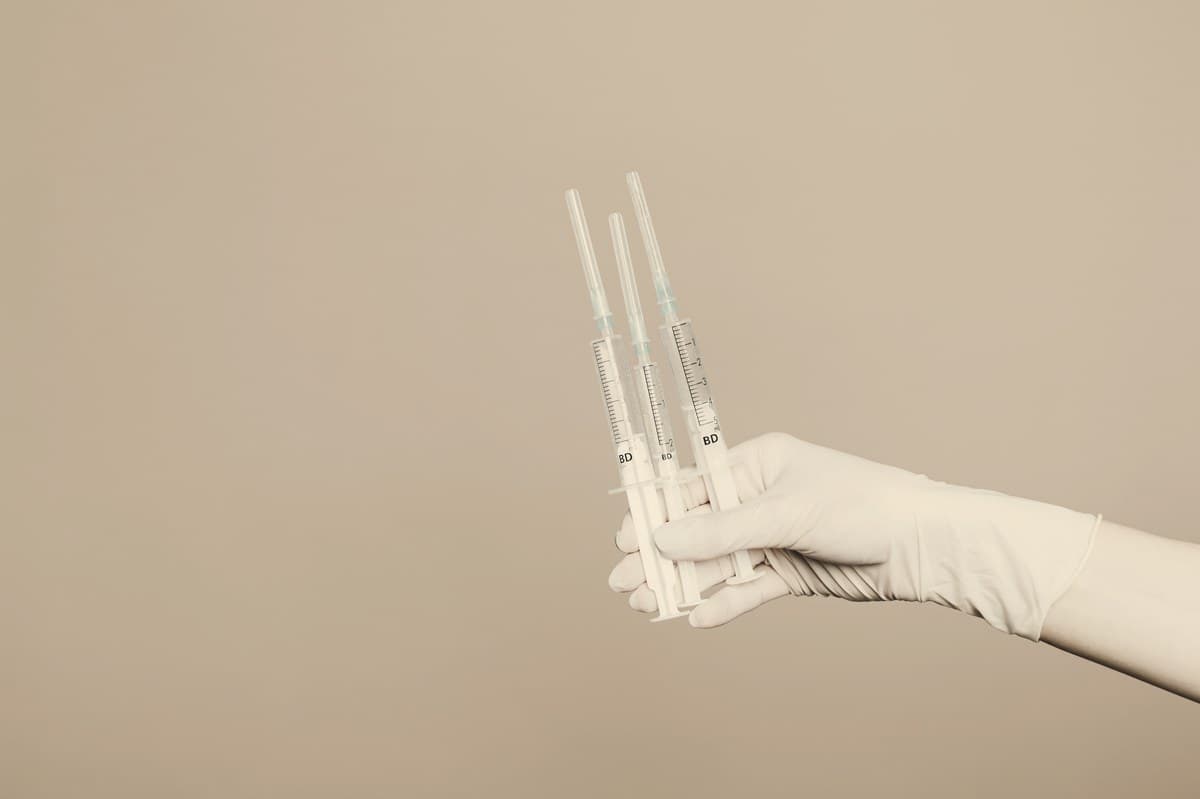A single syringe held against a plain neutral background, illustrating the importance of sourcing skinny shots from licensed providers