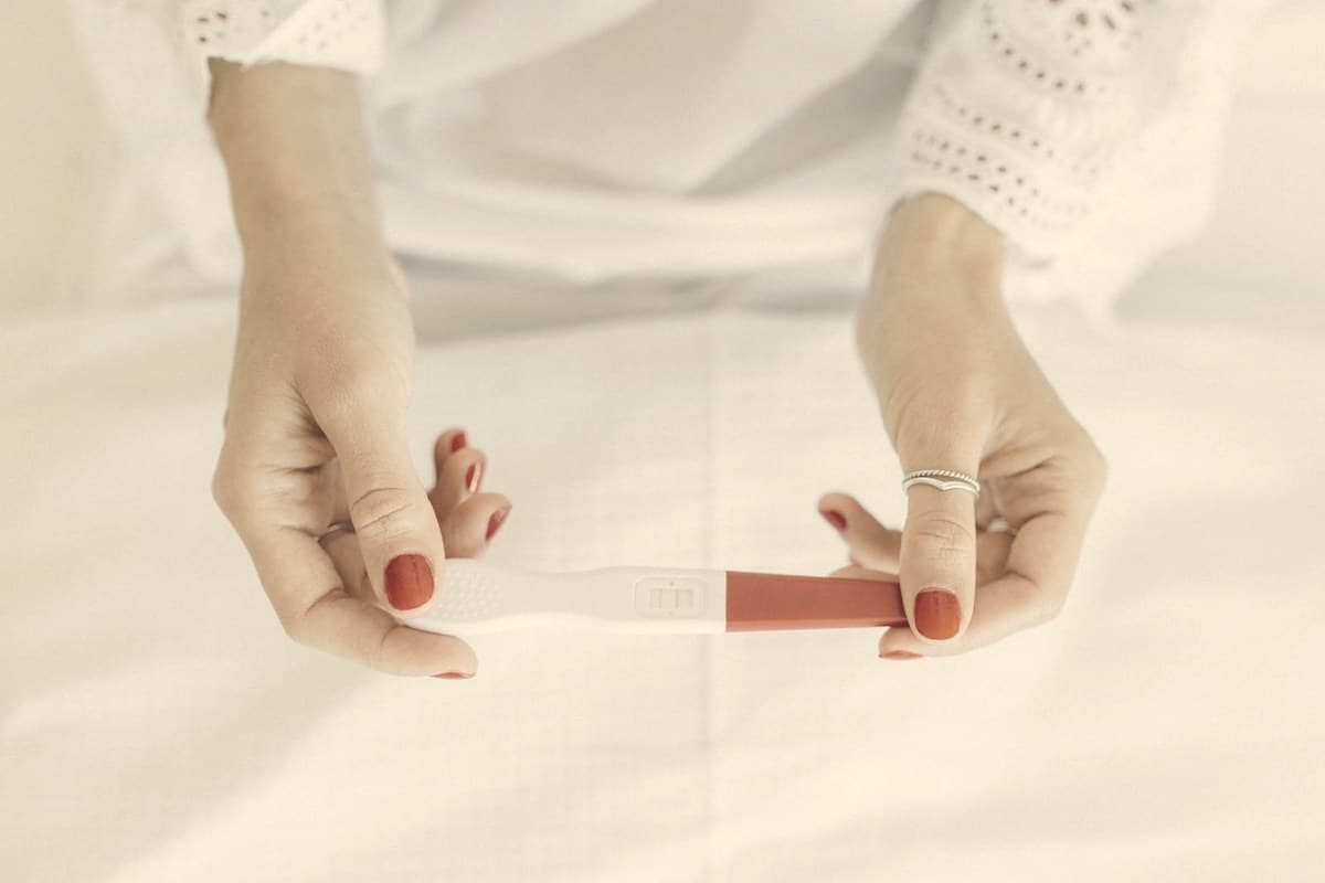 Hands holding a positive pregnancy test — 'Ozempic babies' are unexpected pregnancies in women whose ovulation returned after starting a GLP-1