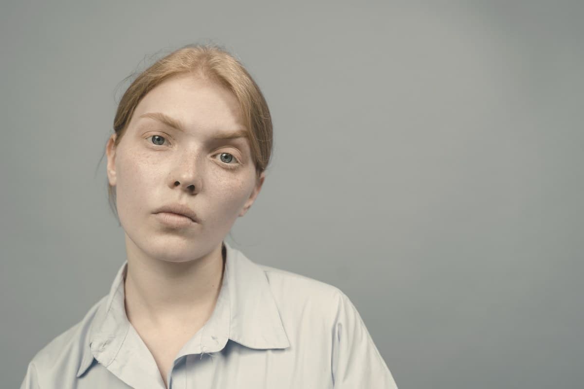 A calm woman in soft natural daylight against a neutral background, representing considerations around Mounjaro side effects specific to women including contraceptive guidance.