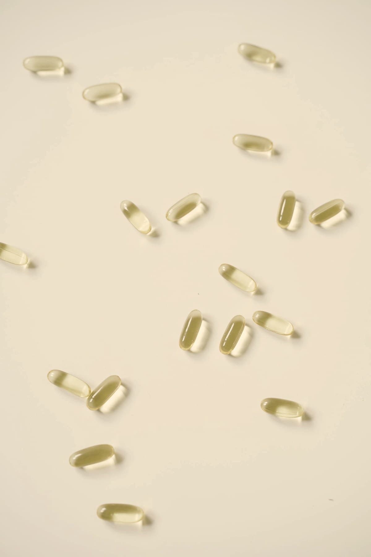 Oral medication capsules scattered on a white surface — orforglipron became the first oral small-molecule GLP-1 approved for obesity in April 2026