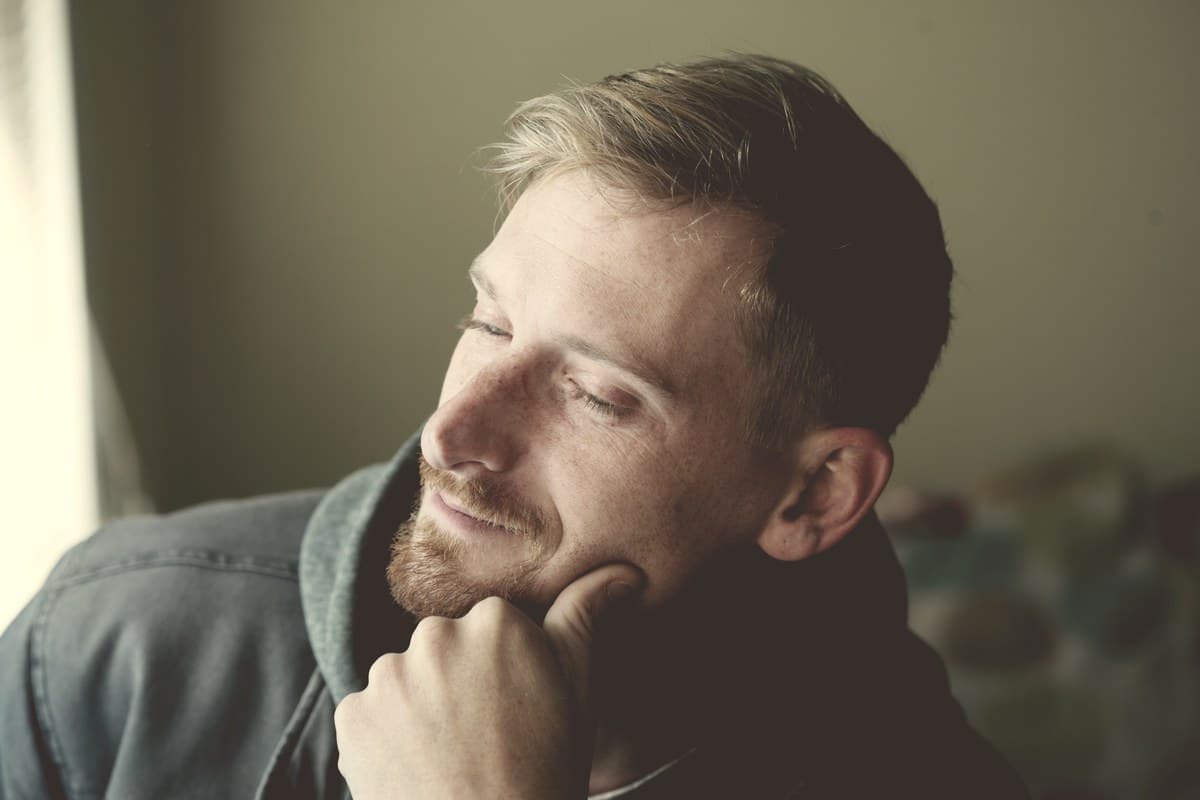 A calm male portrait in soft natural window light, representing how men experience Ozempic side effects differently than women.