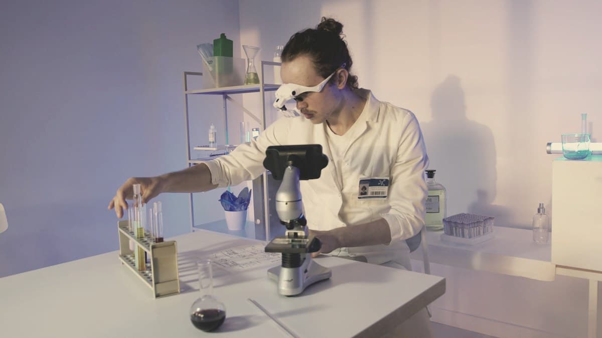 Researcher examining test-tube samples at a microscope in a clinical laboratory — retatrutide is studied in Eli Lilly's Phase 3 TRIUMPH program