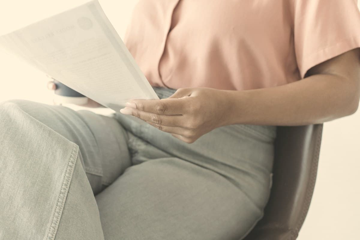 A person quietly reviewing a document at a plain desk in soft natural light, representing the process of navigating Wegovy savings card and insurance options