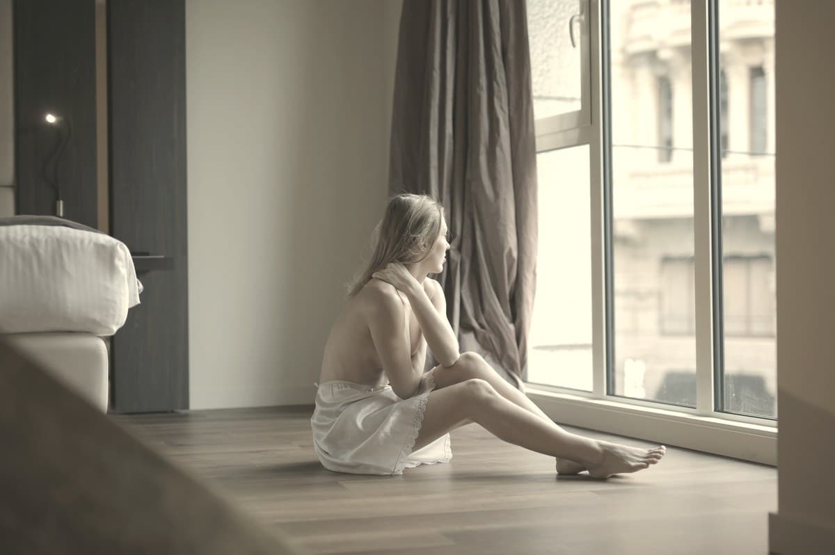Woman seated calmly with hand resting on thigh in soft daylight, representing the thigh as an alternative Ozempic injection site for rotation.