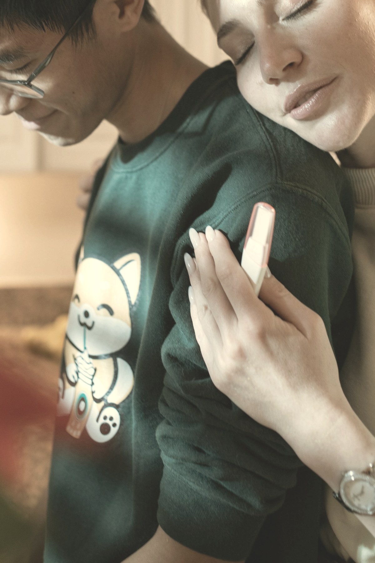 Couple embracing while holding a pregnancy test — experts advise stopping a GLP-1 at least two months before trying to conceive