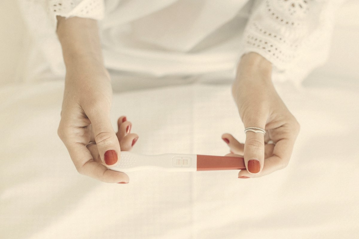 Hands holding a positive pregnancy test — 'Ozempic babies' are unexpected pregnancies in women whose ovulation returned after starting a GLP-1