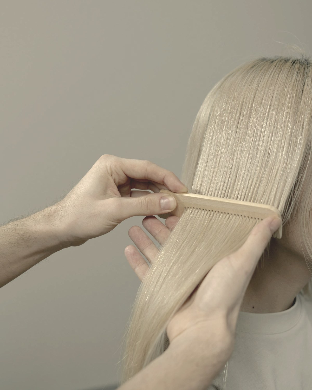 Hands combing long hair with a wooden comb — telogen effluvium causes diffuse shedding three to six months after rapid weight loss begins