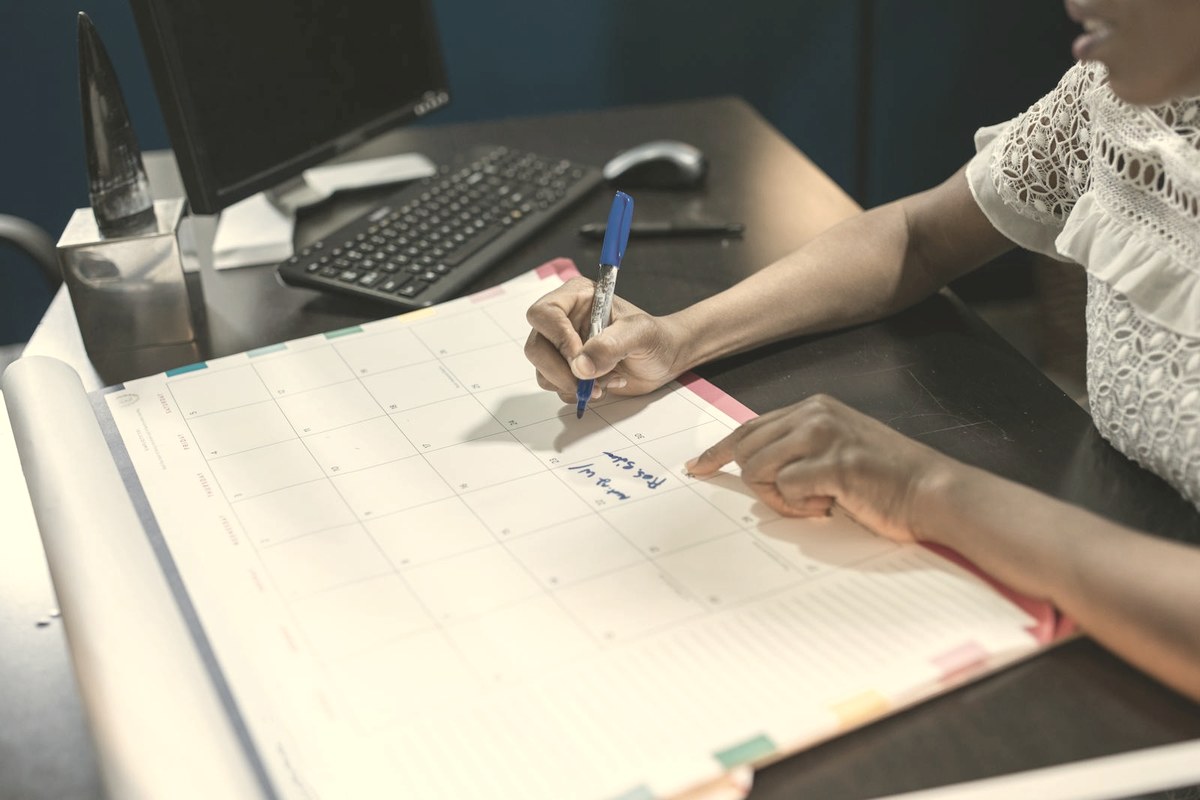 Person marking dates on a wall calendar — GLP-1 side effects follow a predictable week-by-week timeline that resets with each dose increase