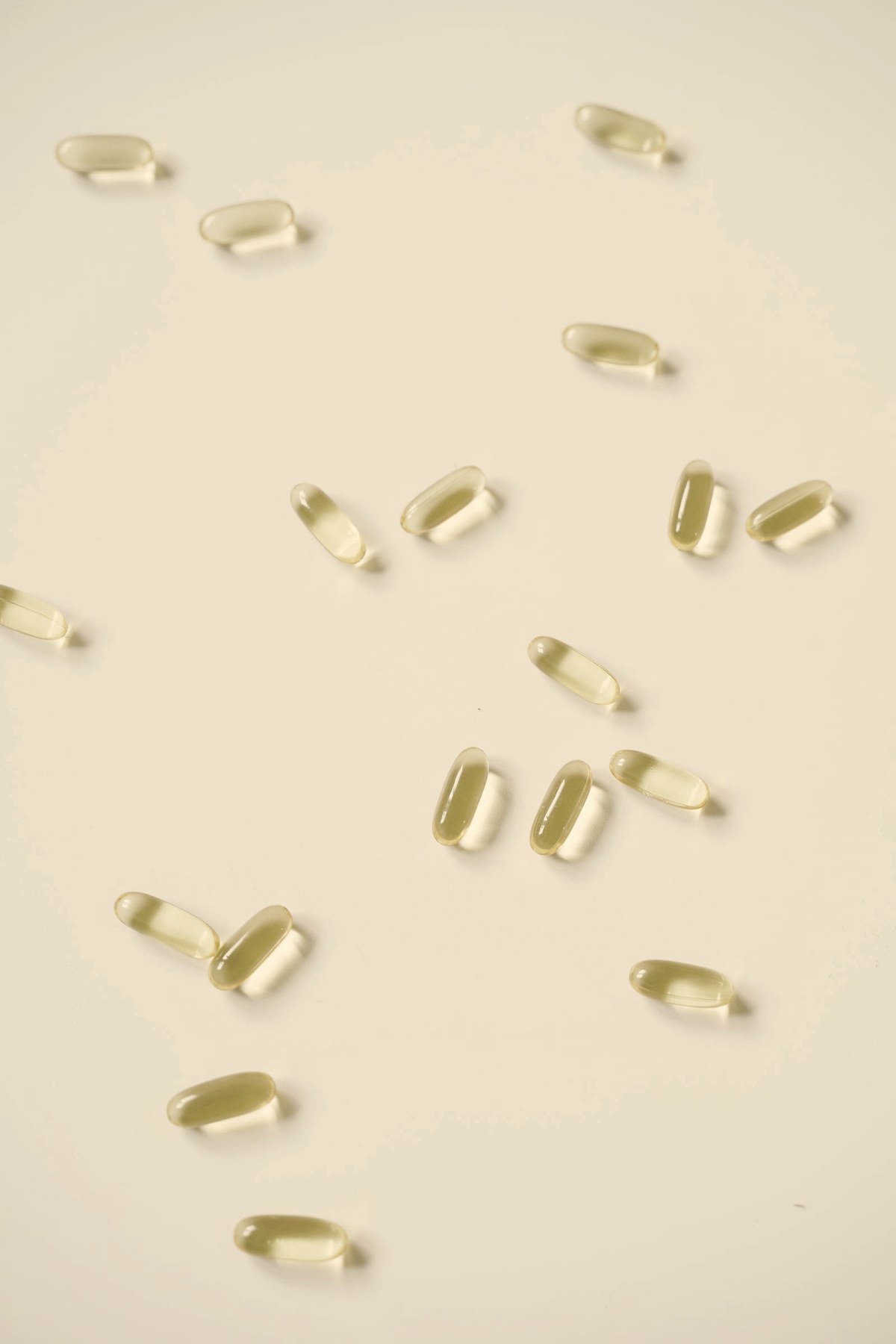 Oral medication capsules scattered on a white surface — orforglipron became the first oral small-molecule GLP-1 approved for obesity in April 2026