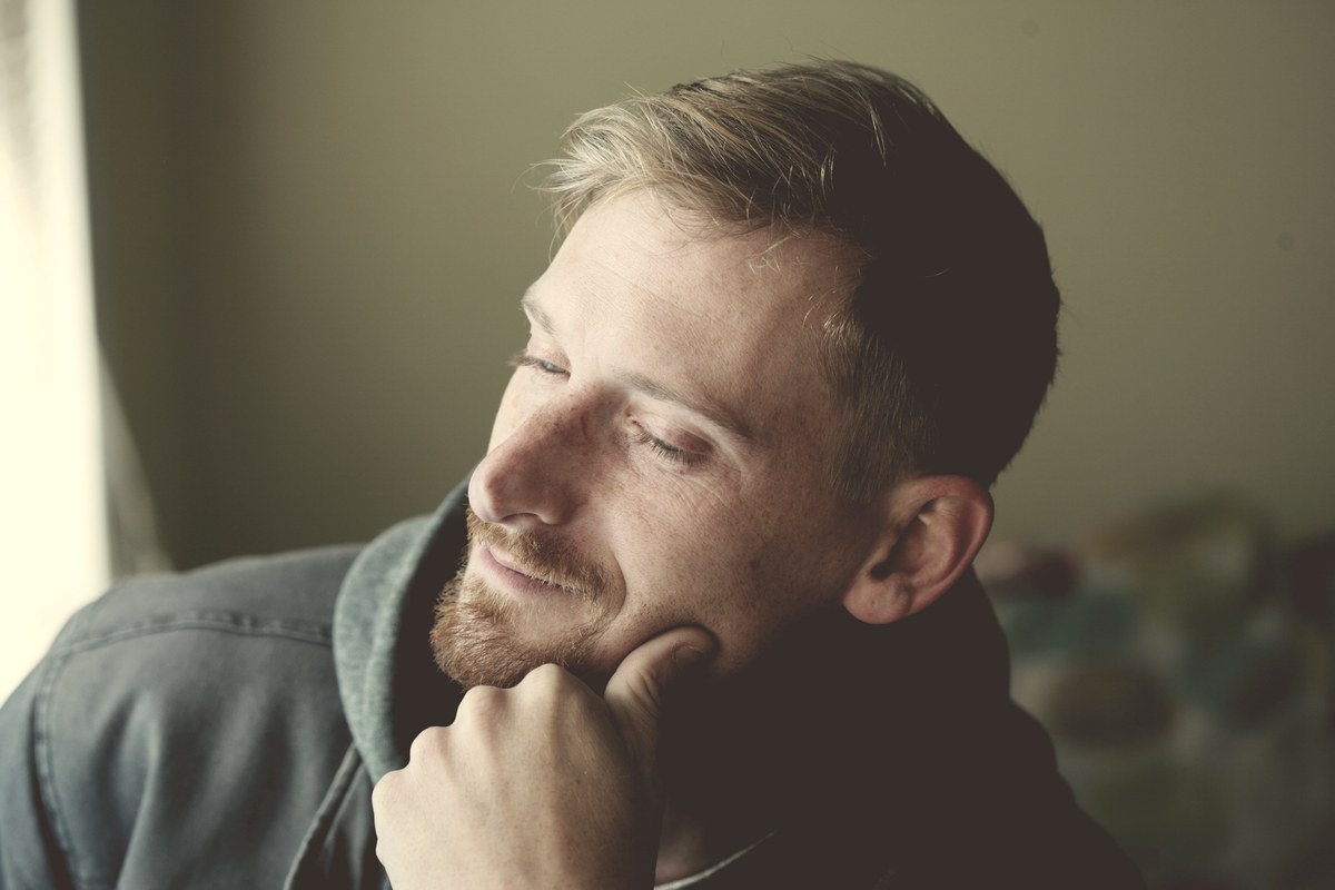 A calm male portrait in soft natural window light, representing how men experience Ozempic side effects differently than women.