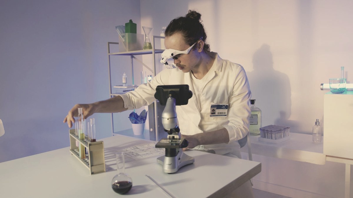 Researcher examining test-tube samples at a microscope in a clinical laboratory — retatrutide is studied in Eli Lilly's Phase 3 TRIUMPH program