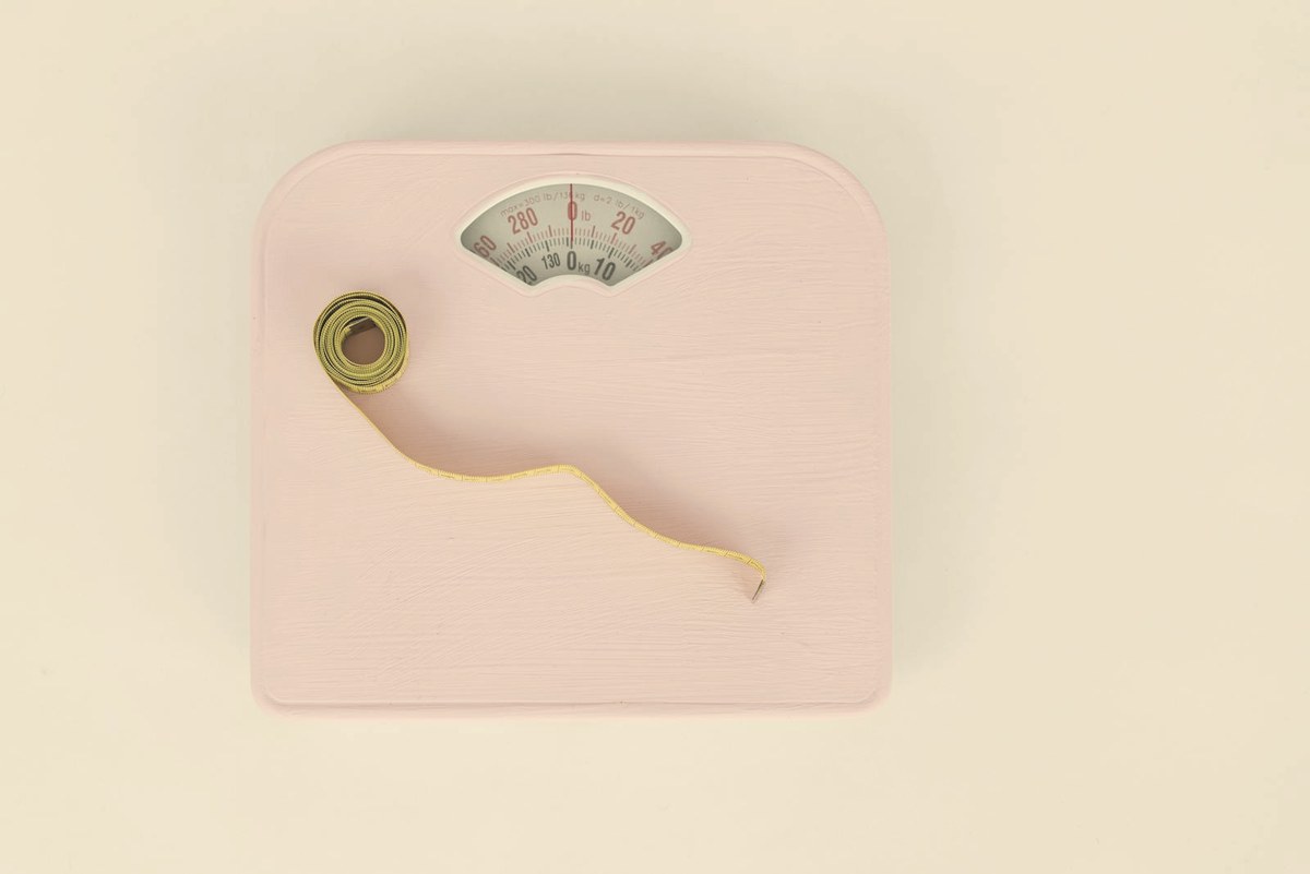 Analog bathroom scale and measuring tape — retatrutide produced up to 30.3% mean body-weight loss in the Phase 3 TRIUMPH-1 trial
